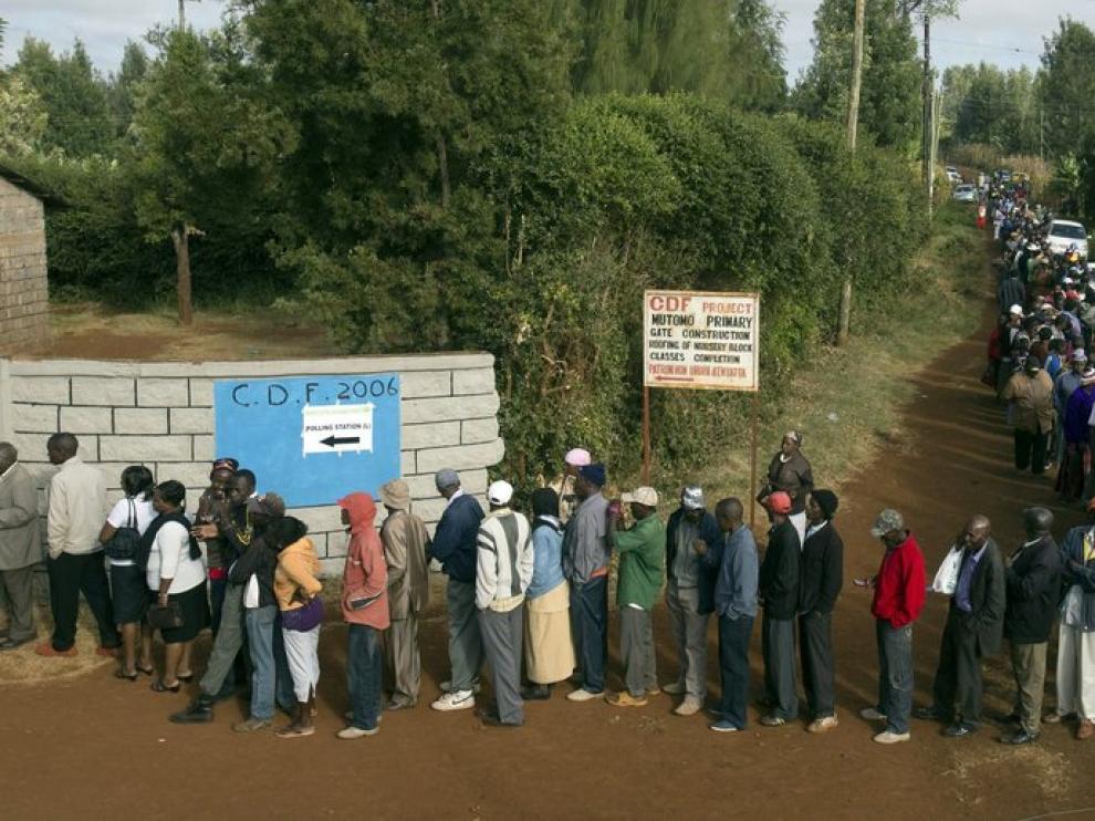 Una larga fila de votantes esperan su turno en uno de los colegios electorales