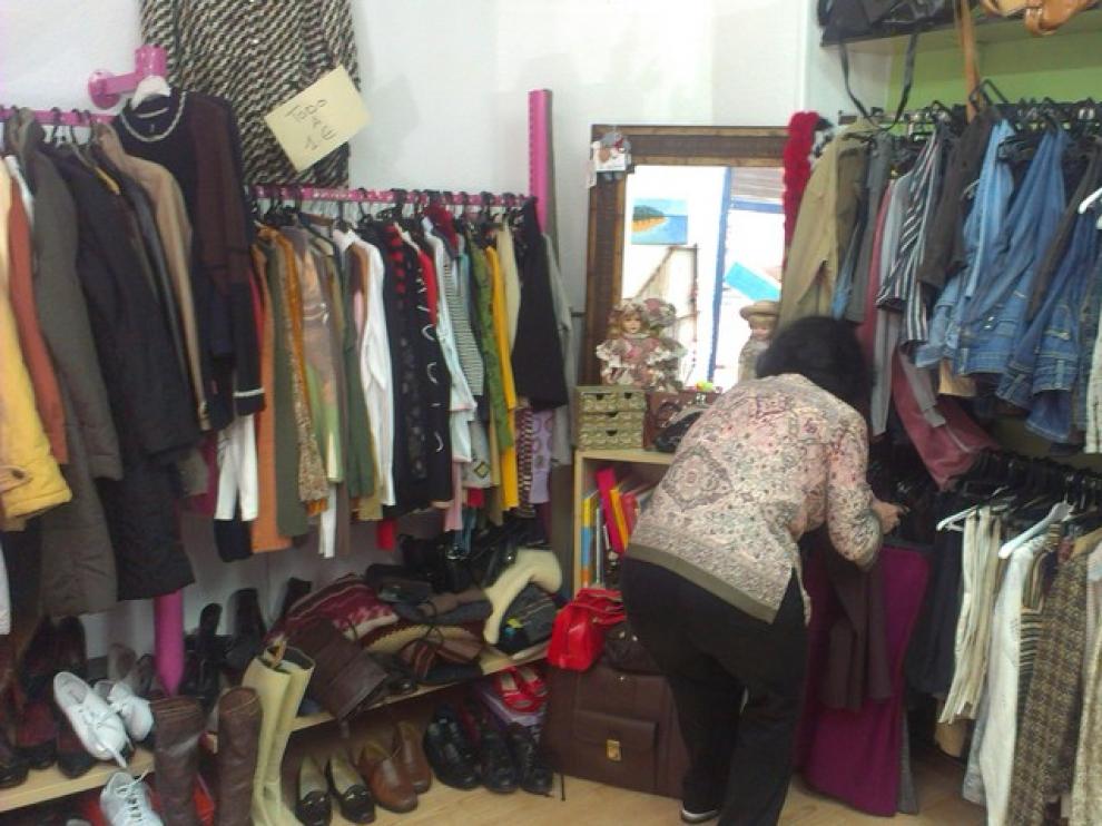 Pilar González, una voluntaria, arregla la ropa expuesta en la tienda.