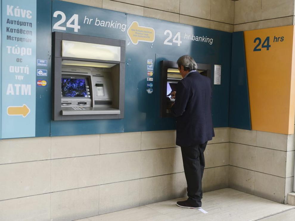 Un hombre retira dinero del cajero