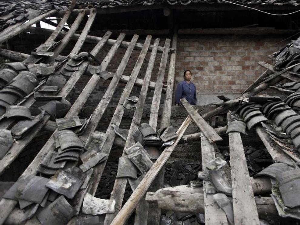 Una mujer contempla las ruinas de su casa tras el terremoto de Sichuan