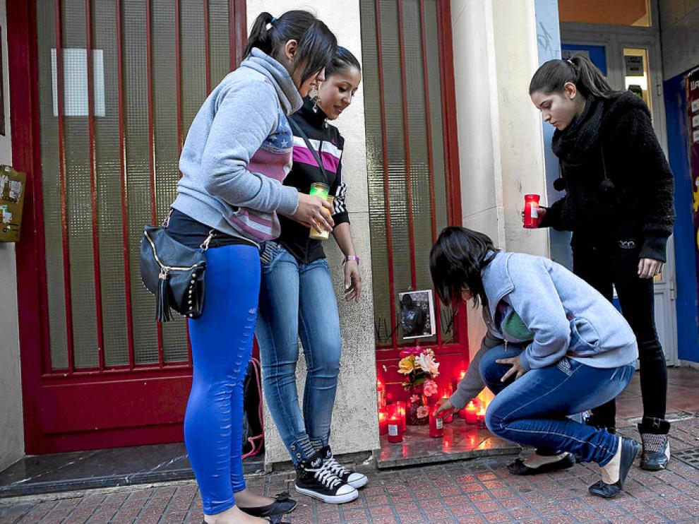Unas amigas de Lamine Gueye, al que conocen como Mou de Delicias, colocan velas en su casa