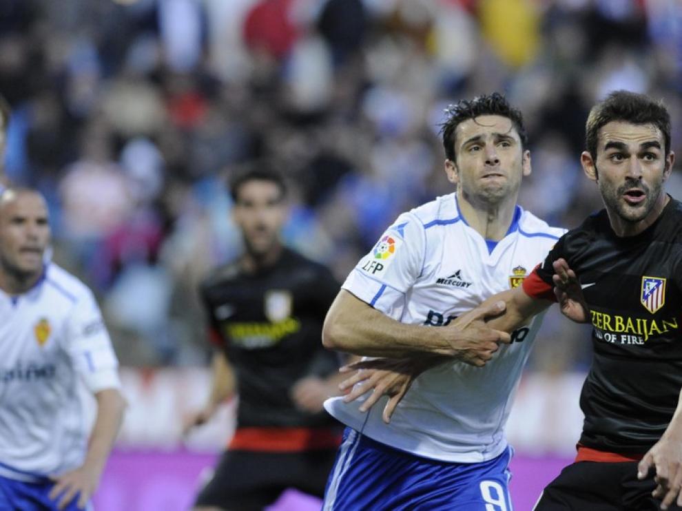 El delantero del Real Zaragoza Hélder Postiga, en pugna con la defensa del Atlético