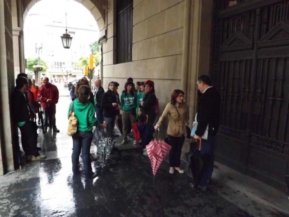 Los manifestantes se protegen de la lluvia en los porches