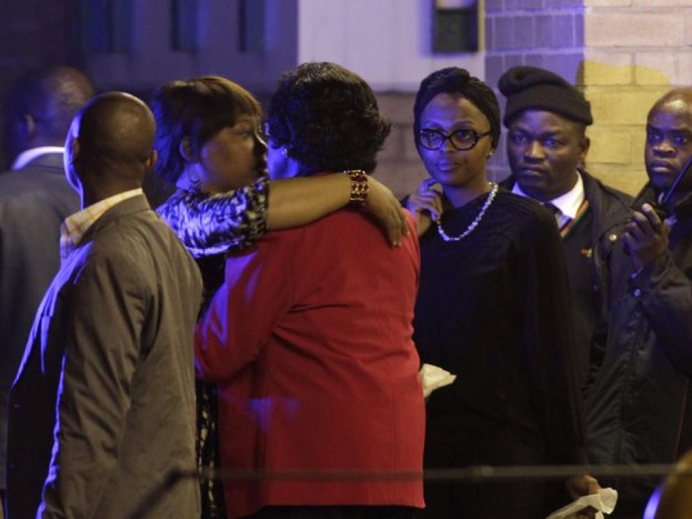 La exmujer de Mandela y su hija se abrazan a la puerta del hospital.