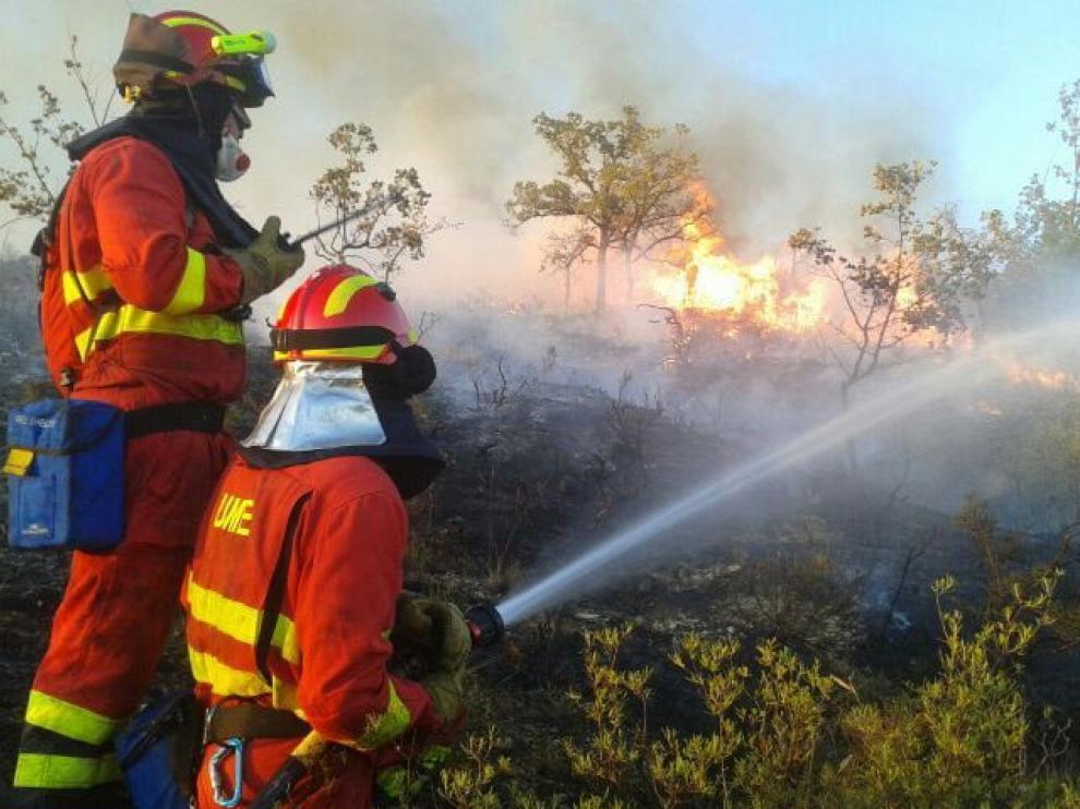 Dos miembros de la UME intentando sofocar un incendio