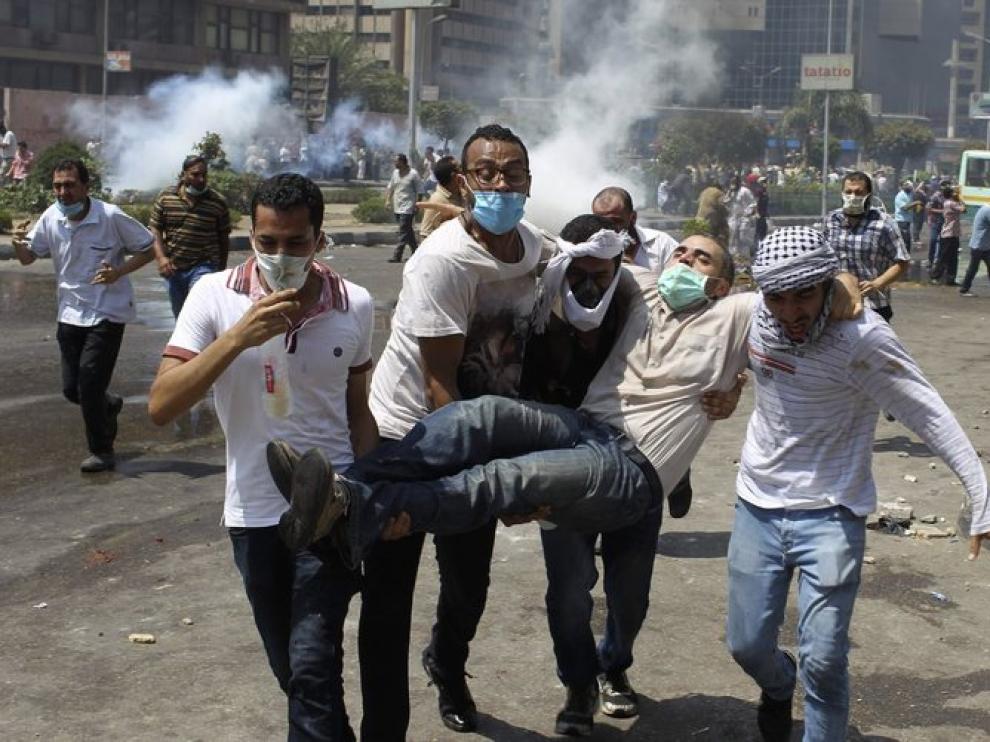 Partidarios del expresidente Mursi evacúan a un herido.