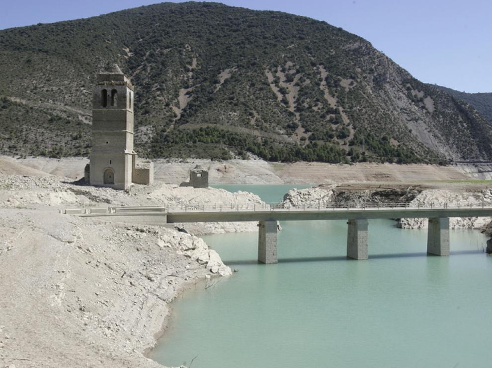 Torre de la iglesia, con el pantano de Mediano sin agua