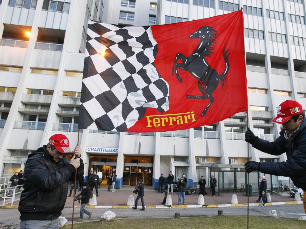 Unos aficionados colocan una bandera de Ferrari a las puertas del Hospital de Grenoble