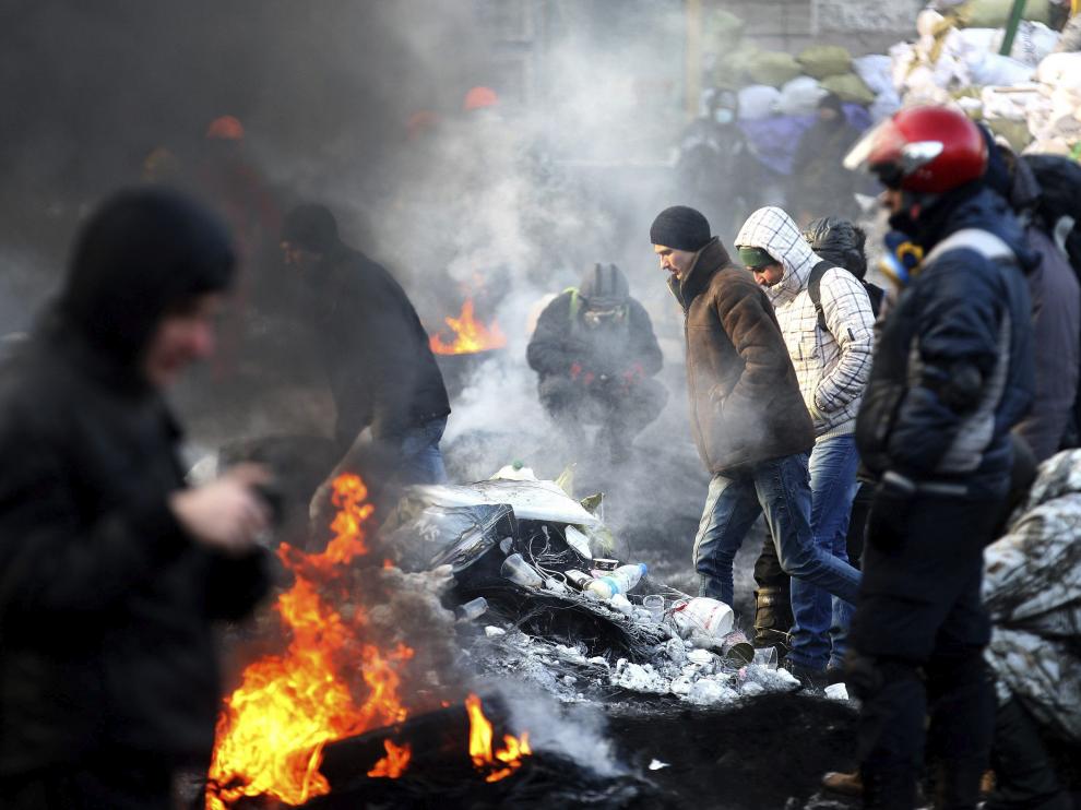 Los manifestantes se calientan en hogueras en las barricadas.