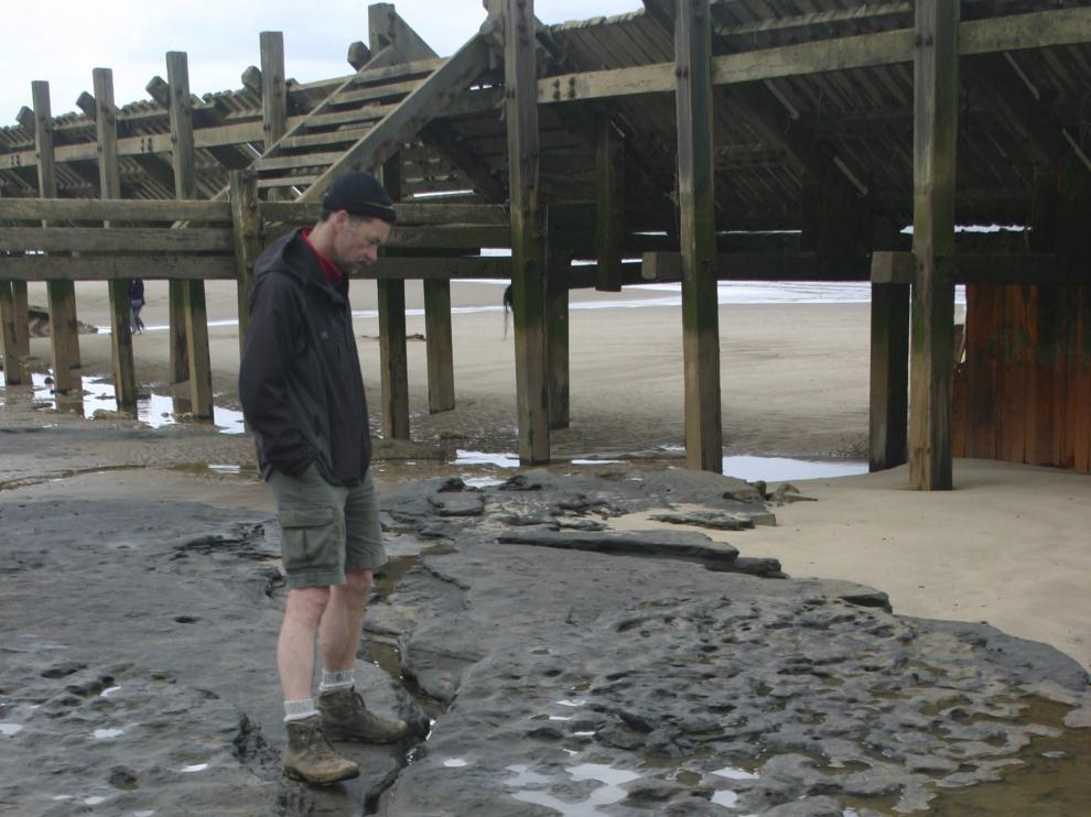 Un hombre observa las huellas en Happisburgh