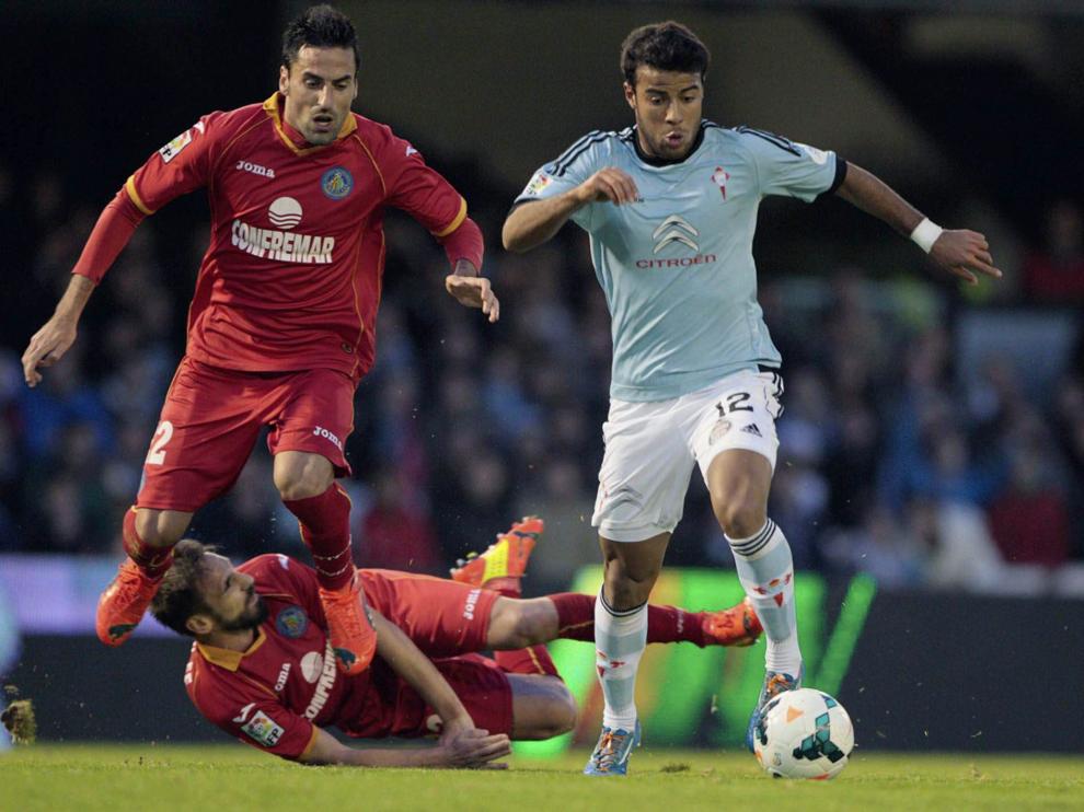 El centrocampista del Celta de Vigo Rafa Alcantara do Nascimento (d) controla el balón ante los jugadores del Getafe.