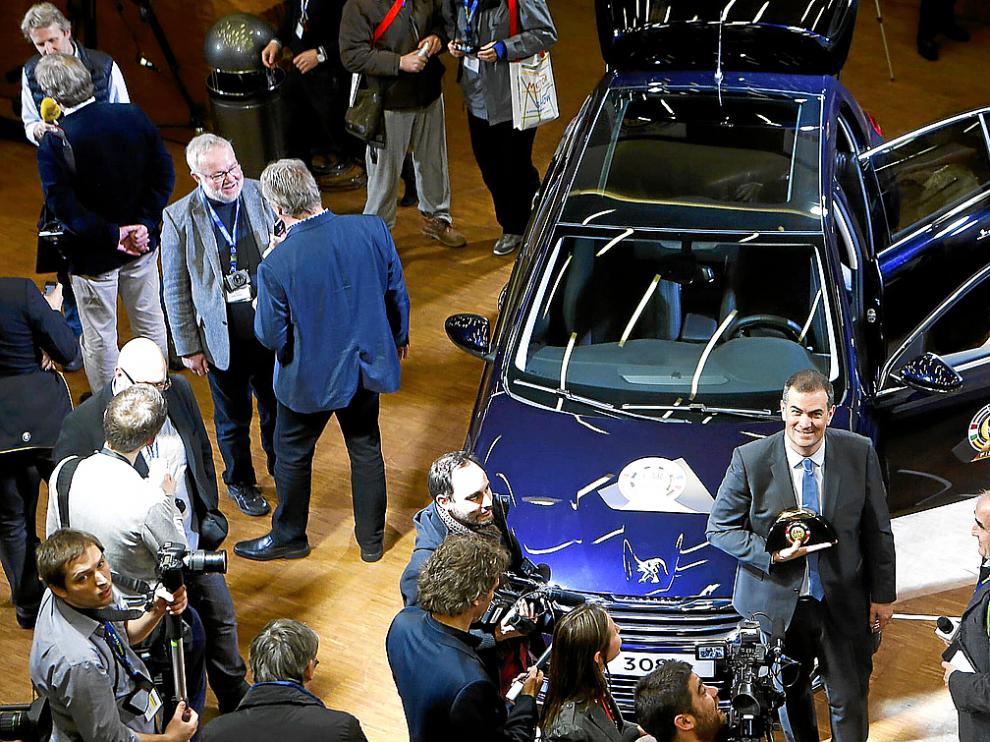 Maxime Picat posa, delante del Peugeot 308, con el galardón, en el salón de Ginebra.