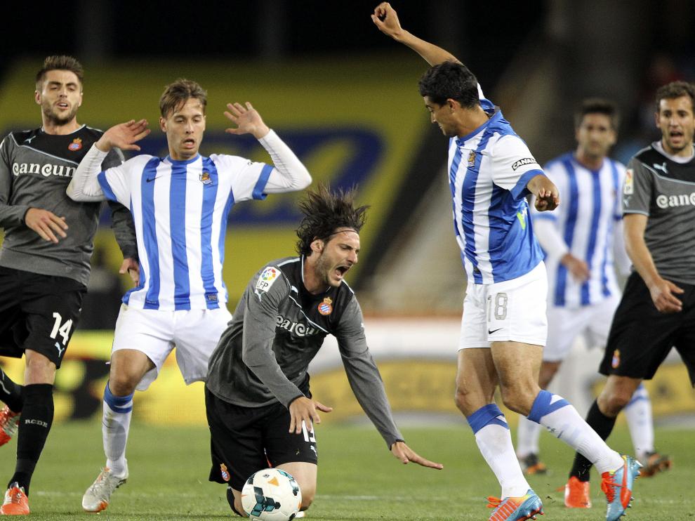 El defensa del Espanyol, Diego Colotto (c), cae entre Sergio Canales (2i) y Gonzalo "Chory" Castro (d), de la Real Sociedad.
