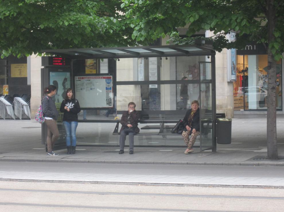 Varias personas esperan en una parada de bus durante uno de los paros