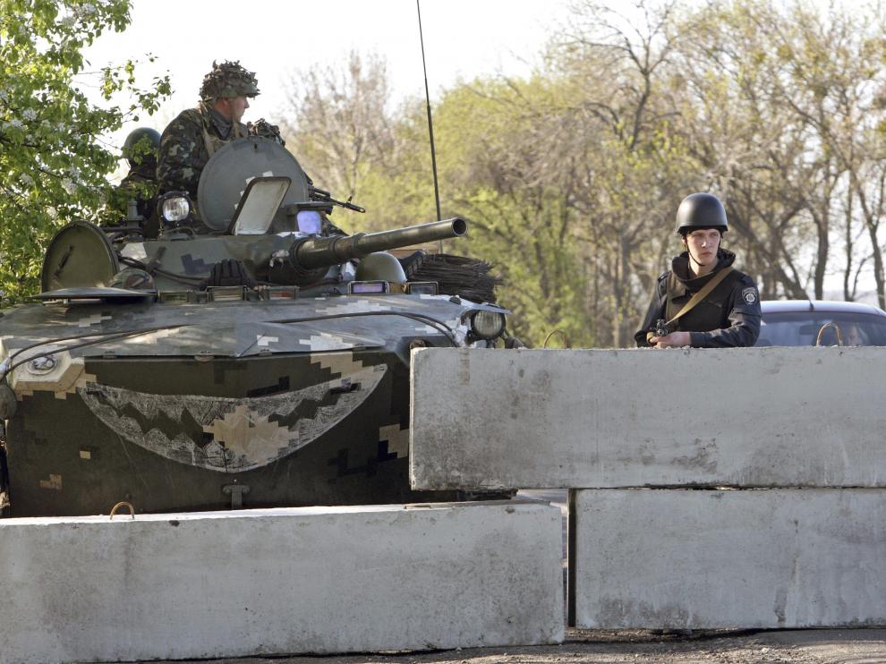 Varios soldados ucranianos vigilan, desde detrás de un muro, en un puesto de control situado a 30 kilómetros de la ciudad de Slaviansk