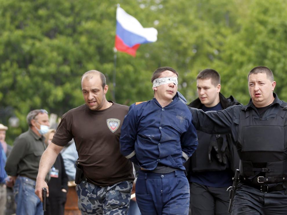Activistas prorrusos escoltan a un hombre sin identificar en Donetsk
