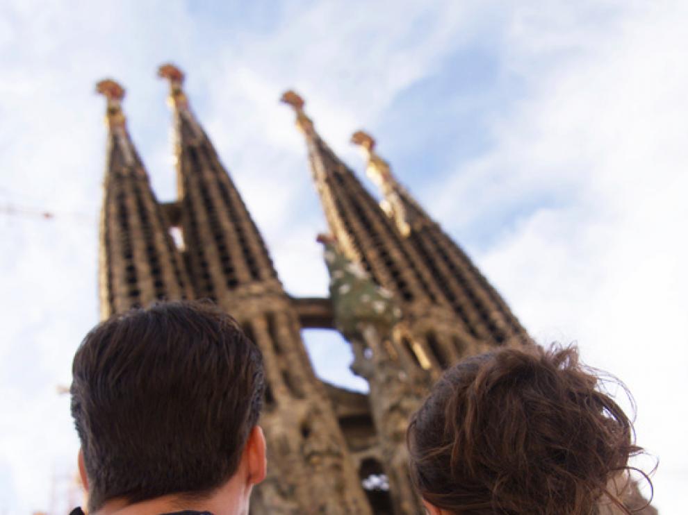 Una pareja contempla la Sagrada Familia de Barcelona.