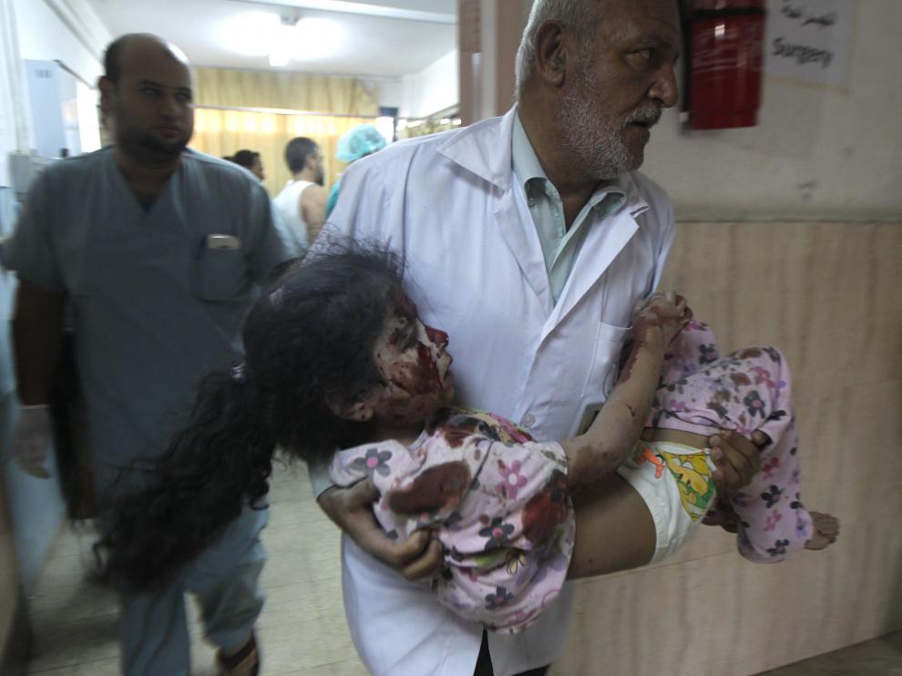 Un médico palestino traslada a una niña herida en Khan Yunis