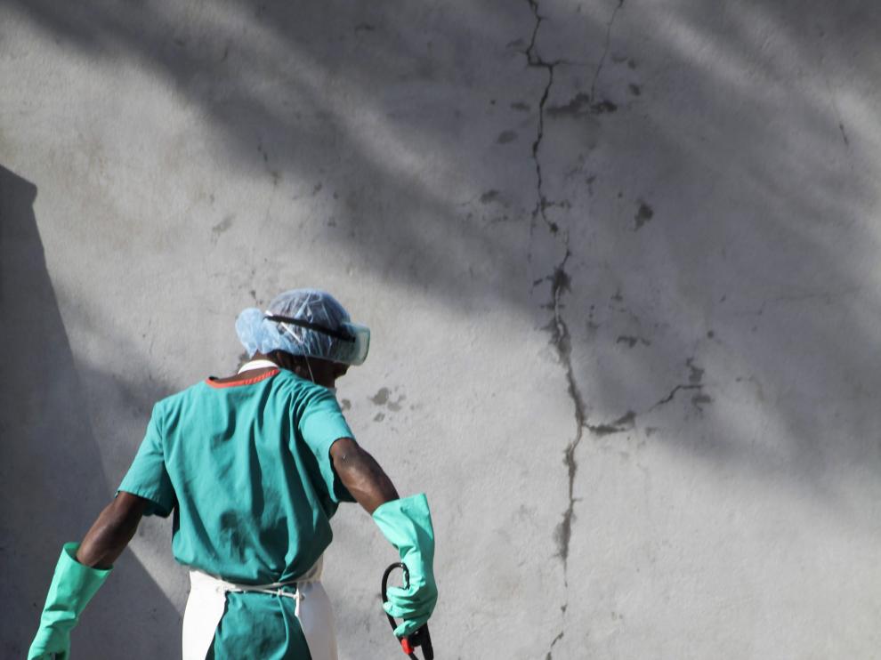 Un trabajador sanitario rocía su calzado con desinfectante para evitar el contagio del virus del ébola en Liberia