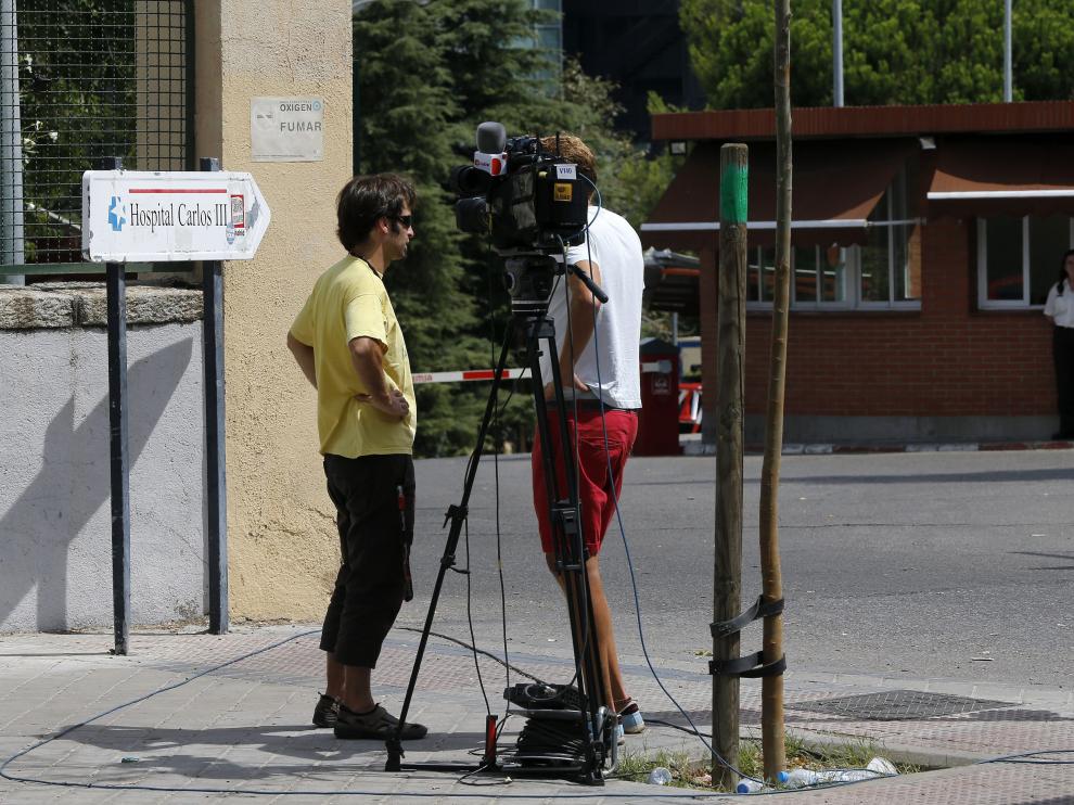 Dos reporteros de televisión graban en las inmediaciones del Hospital Carlos III