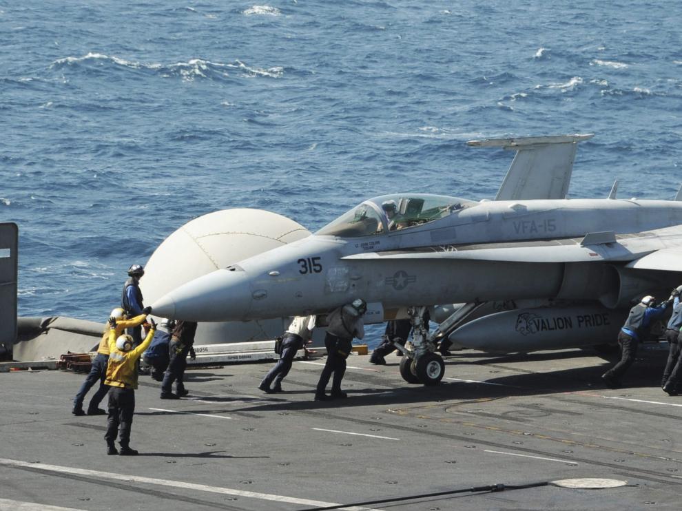 Marines de EE UU guían el despegue de un avión desde el portaaviones Georges Bush