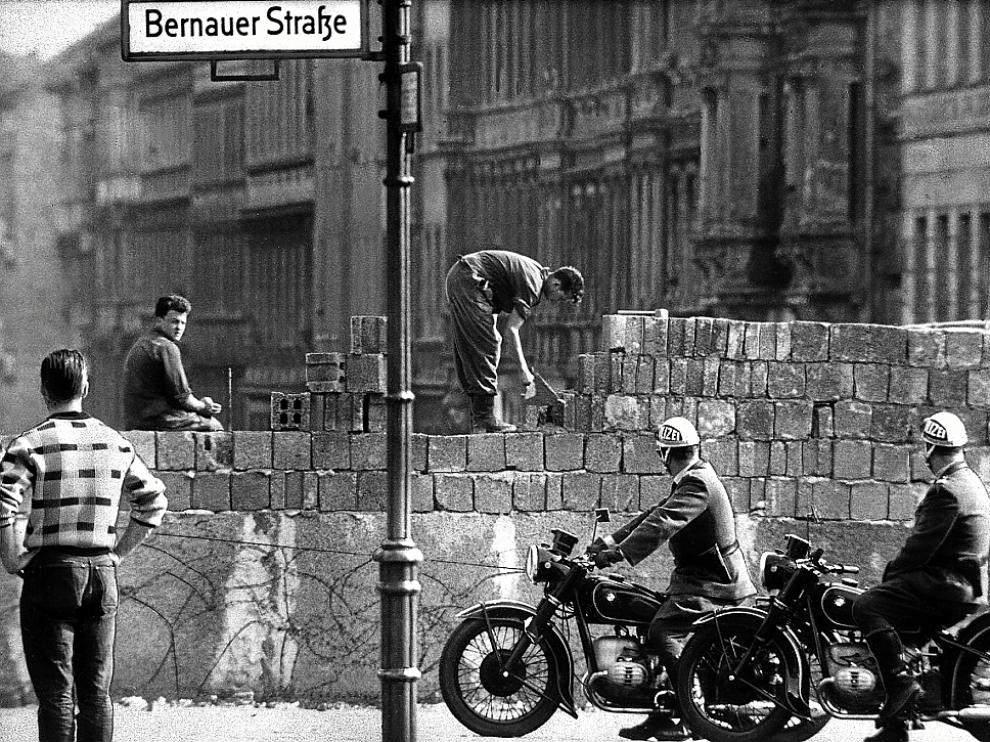 Soldados alemanes levantando el muro, ante el asombro de los ciudadanos.