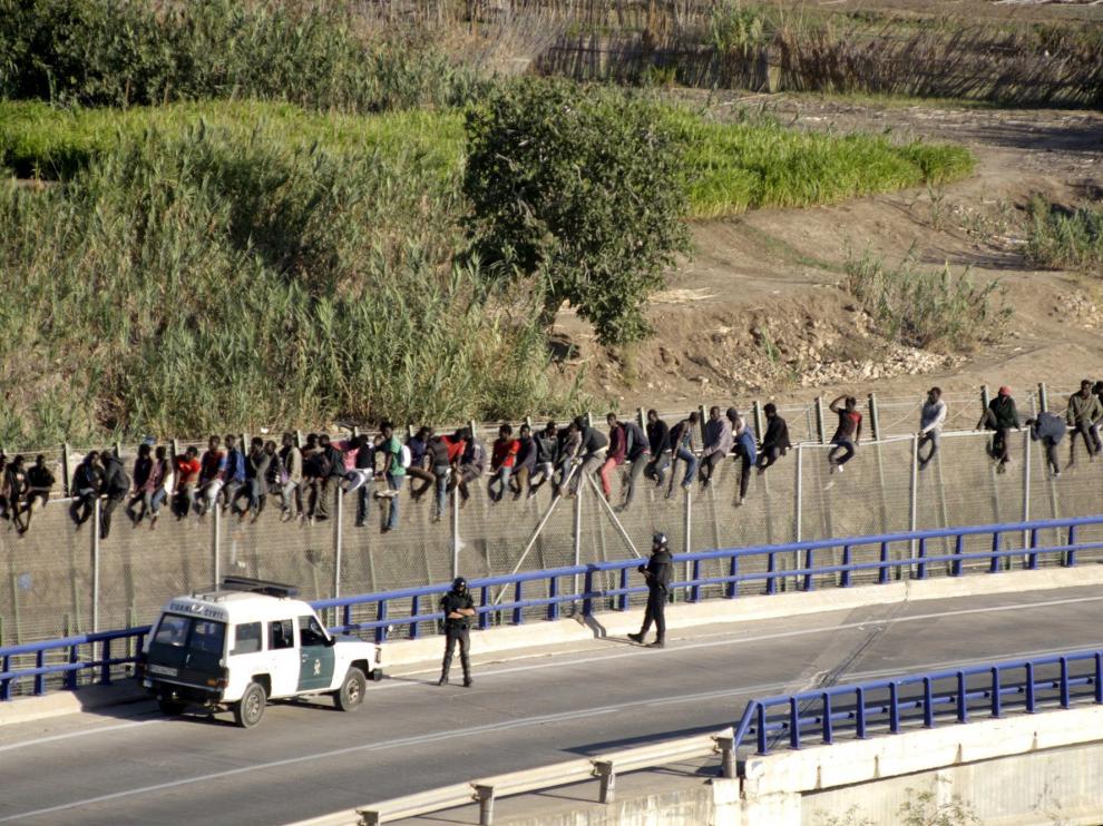 Inmigrantes encaramados en la valla de Melilla
