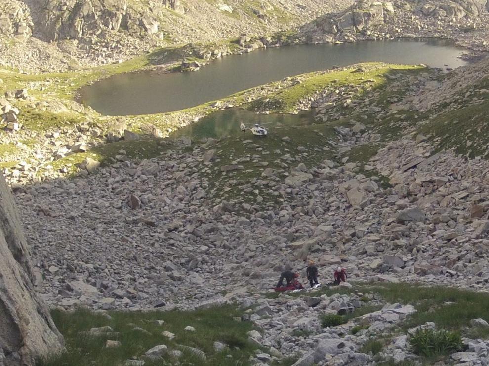 Los agentes (en la pedreguera) recogen el cadáver del montañero fallecido en Vallibierna.