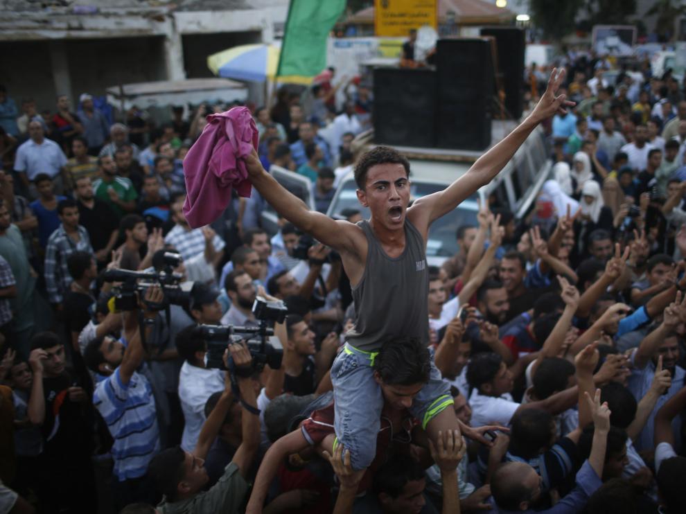 Miles de gazatíes se echaron a las destruidas calle de Gaza para celebrar, con disparos al aire.