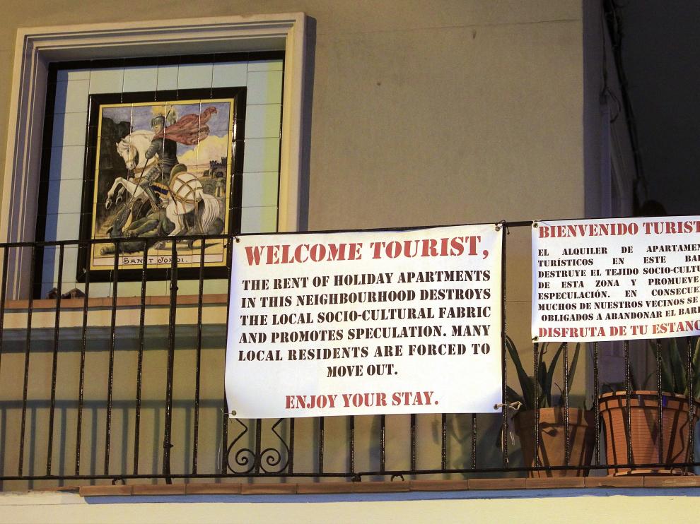 Cartel de los vecinos a los turistas en un balcón del barrio