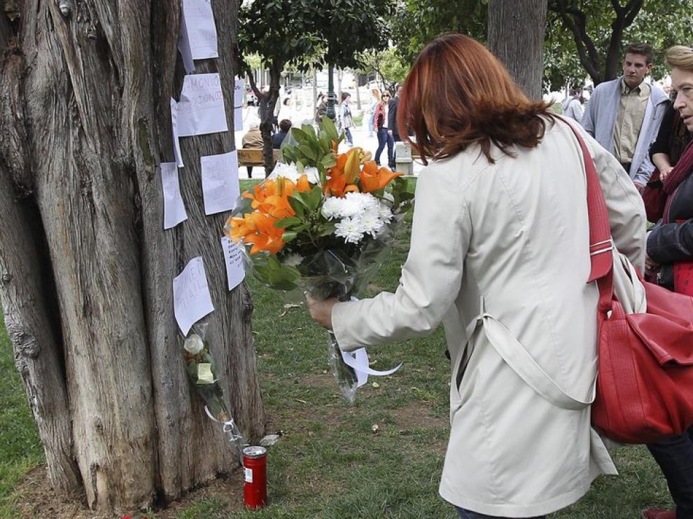 Una mujer deja un ramo de flores en el lugar de un suicidio, en Grecia