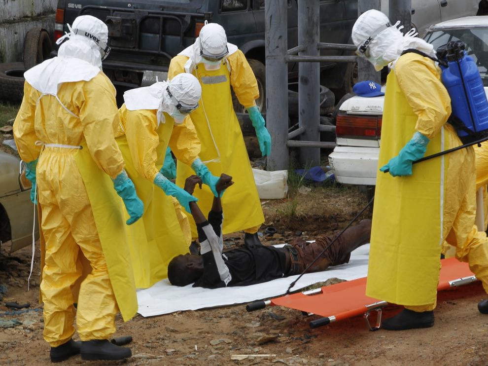 Varios especialistas transportan el cuerpo sin vida de una víctima del virus del ébola.