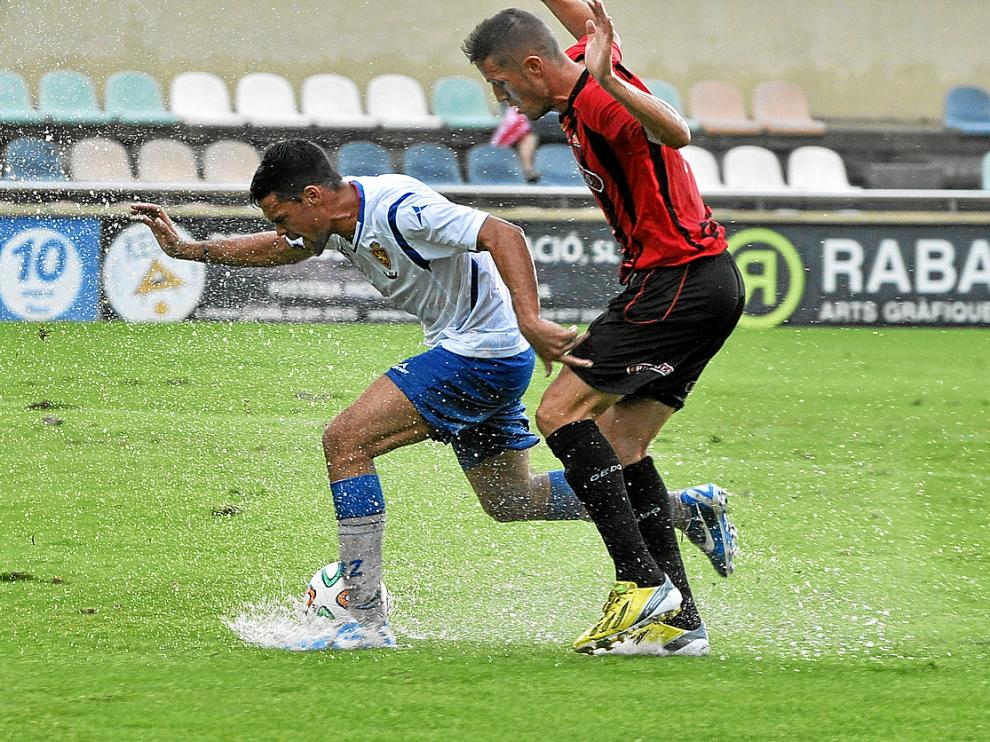 Marc Vales intenta avanzar pese al rival y a la lluvia.