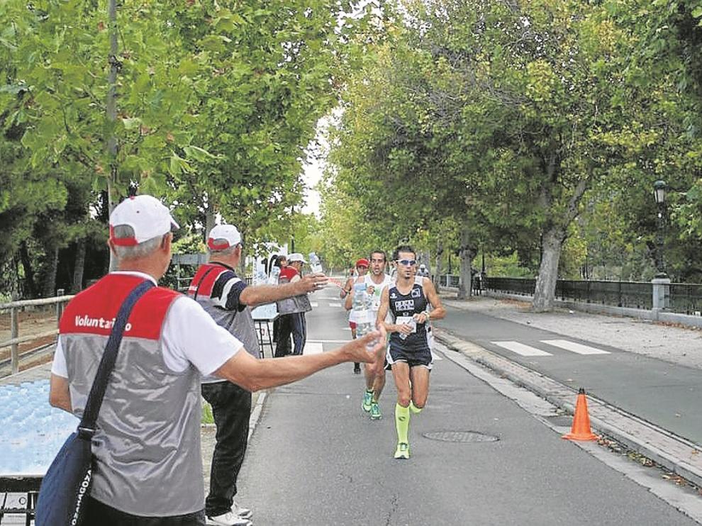 Un grupo de corredores del Maratón pasa por un punto de avituallamiento en la pasada edición.