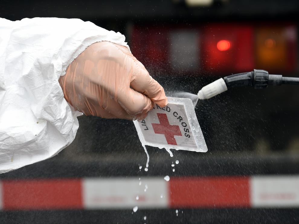Personal sanitario de Cruz Roja desinfecta su tarjeta de identificación en Liberia.