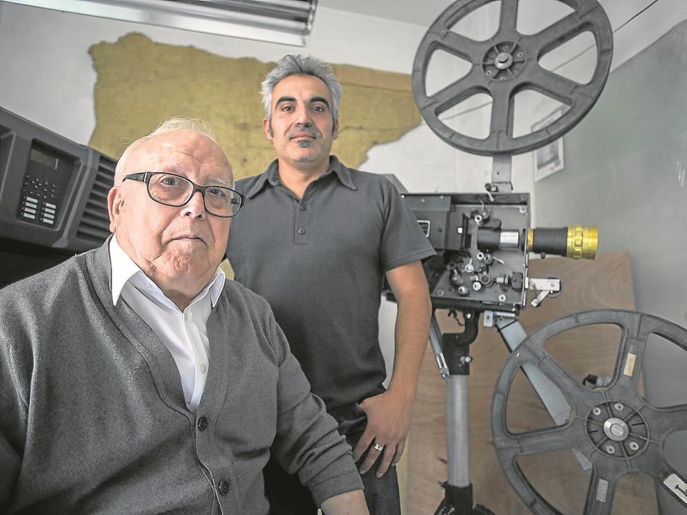 Generoso y Óscar Hernández, delante de un proyector portátil de 35 mm
