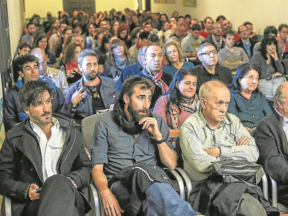 Ricardo García Vilanova (i) y Manu Brabo, a su lado, entre el público durante la inauguración.