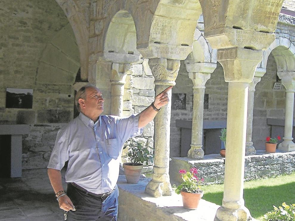 Aurelio Ricou, el párroco, ante algunas de las inscripciones afectadas.