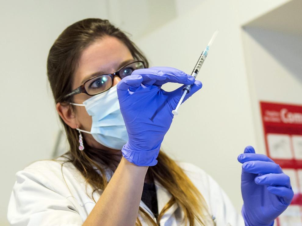 Una enfermera sostiene una dosis de la vacuna experimental contra el ébola antes de inyectásela a un voluntario de una ONG