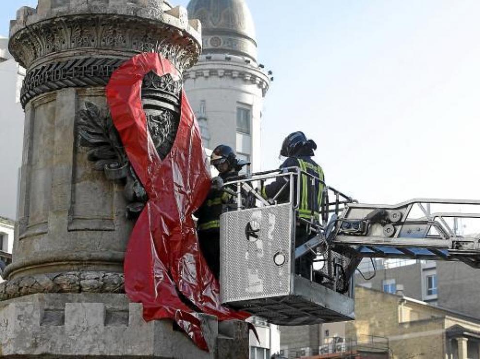 Los Bomberos colocaron un gran lazo rojo en el monumento de la plaza de España el año pasado