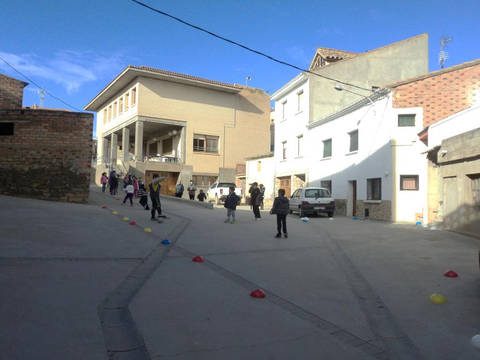 Los niños no tienen patio y juegan en la calle. Al fondo, el salón social, que hace de colegio.