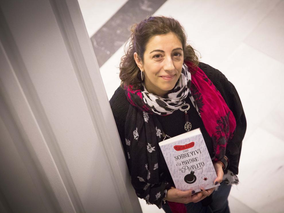 La escritora María Frisa junto a su libro 'Cómo sobreviví a la madre de Pavlito (con uve)'