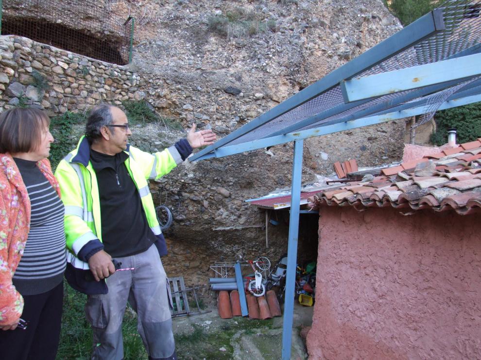 El alguacil y una vecina de Los Fayos frente al tejado donde cayó la última piedra.