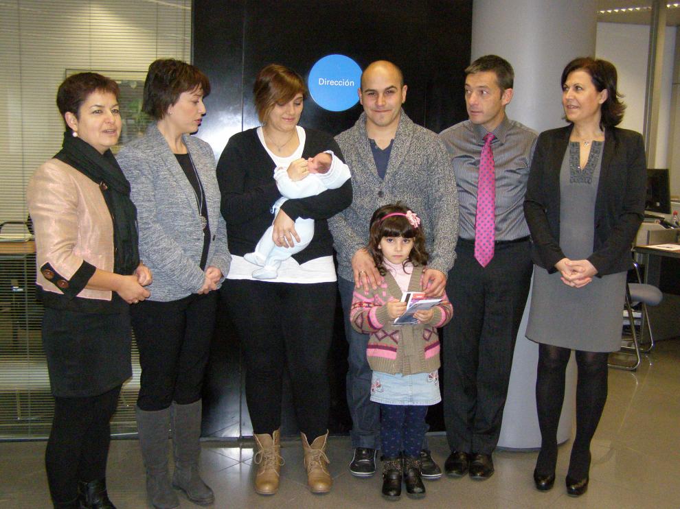 La familia del primer bebé posa con responsables de ACT y La Caixa.