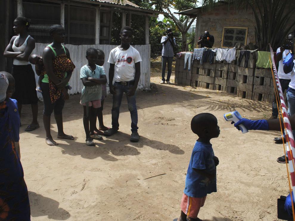 Un médico toma la temperatura a un niño en un barrio de Monrovia, en Liberia, el pasado miércoles