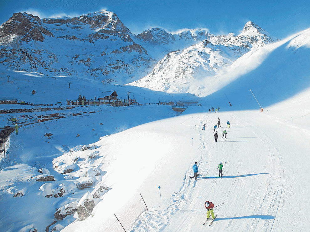 Esquiadores en la estación de Formigal, en cuyas cumbres se ve la nieve que levanta el viento