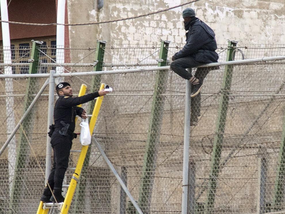 Imagen de archivo de un inmigrante encaramado a la valla de Melilla
