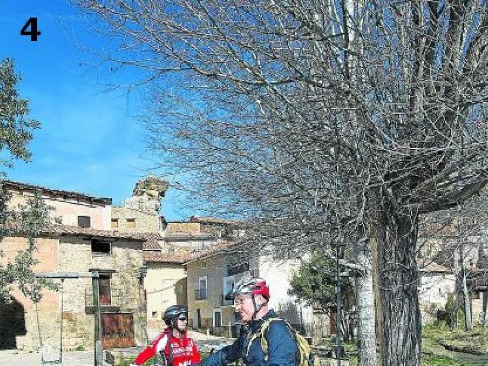 Dos ciclistas castellonenses, Vicente y Puri, reponen fuerzas durante un viaje por el Maestrazgo en la entrada al pueblo. El eslogan 'Miravete, el pueblo en el que nunca pasa nada' todavía es un referente para ellos.