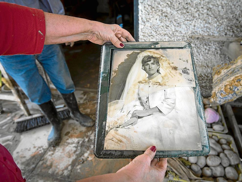 Mª Pilar Oquendo muestra el estado en el que ha quedado su foto de boda tras inundarse su casa.