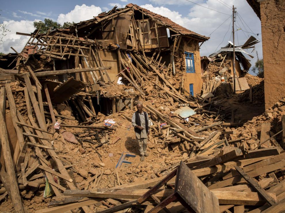 Un hombre camina sobre los escombros en un poblado de Katmandú, en Nepal.